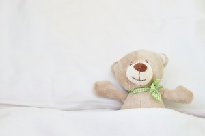 Cute bear lying on bed.