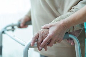 Close-up of woman using walker assisted by carer