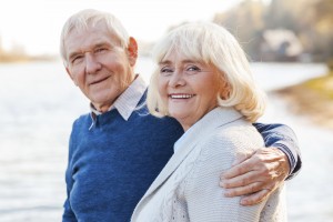 We are happy together. Happy senior couple bonding to each other and smiling while standing on the quayside together