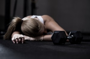 Young exhausted girl lying on a floor after training