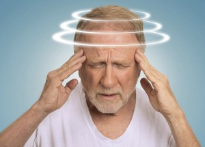 Headshot senior man with vertigo. Elderly male patient suffering from dizziness isolated on light blue background .