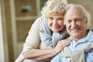 Affectionate elderly man and woman looking at camera